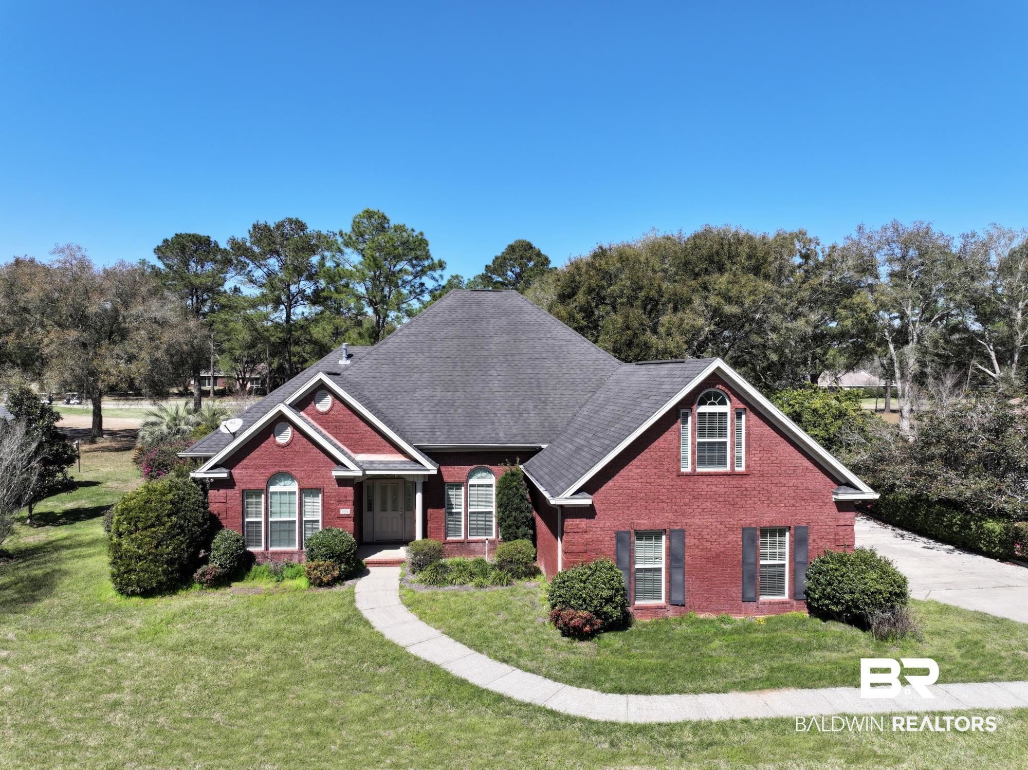 306 South Tee Drive Fairhope, AL 36532 - Photo 2 of 37 View of front of house with brick siding, a front yard, and a shingled roof