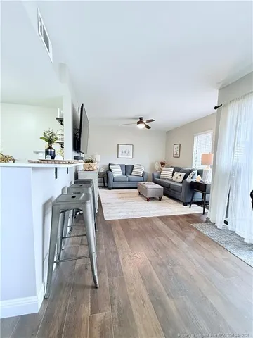 a living room with furniture a flat screen tv and a table