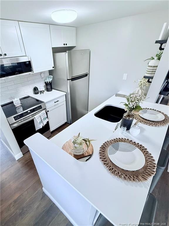 5 Pine Tree Road Pinehurst, NC 28374 - Photo 18 of 45 a kitchen with stainless steel appliances granite countertop a sink dishwasher a stove a refrigerator and a dining table with wooden floor