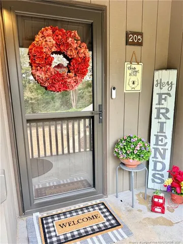a vase of flowers sitting on a table in front of a door