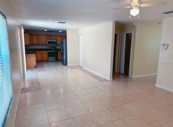 an empty room with kitchen and fireplace