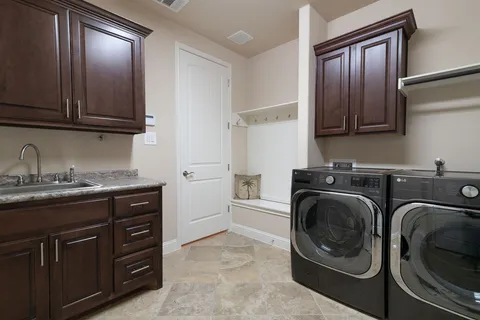 a utility room with sink dryer and washer