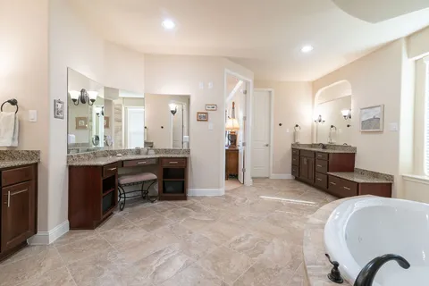 a large spacious bathroom with a granite countertop sink a mirror and a shower
