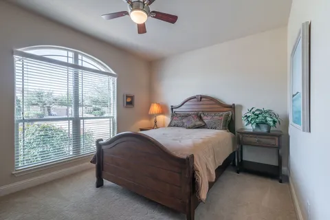 a bedroom with a bed and a large window