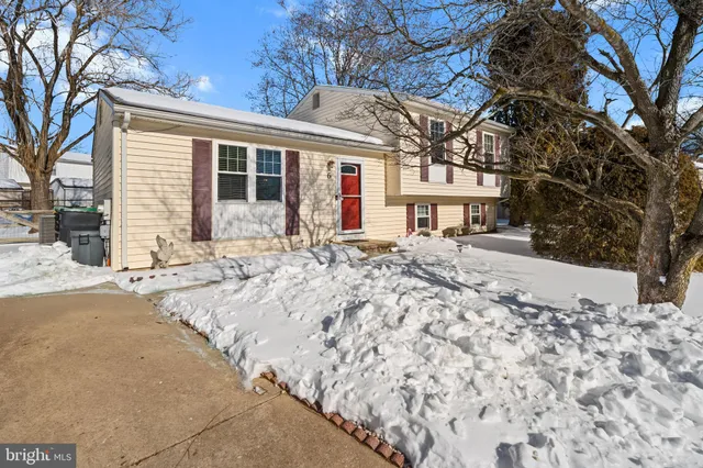 a front view of a house with a yard covered in snow