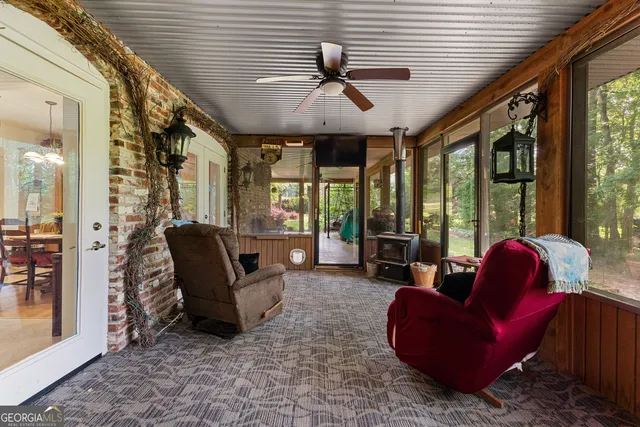 a kitchen view with stainless steel appliances kitchen island granite countertop a refrigerator a stove a dining table and chairs with wooden floor