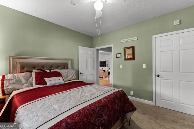 a view of a livingroom with a ceiling fan & windows