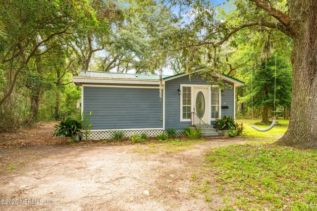 a view of a house with backyard and sitting area