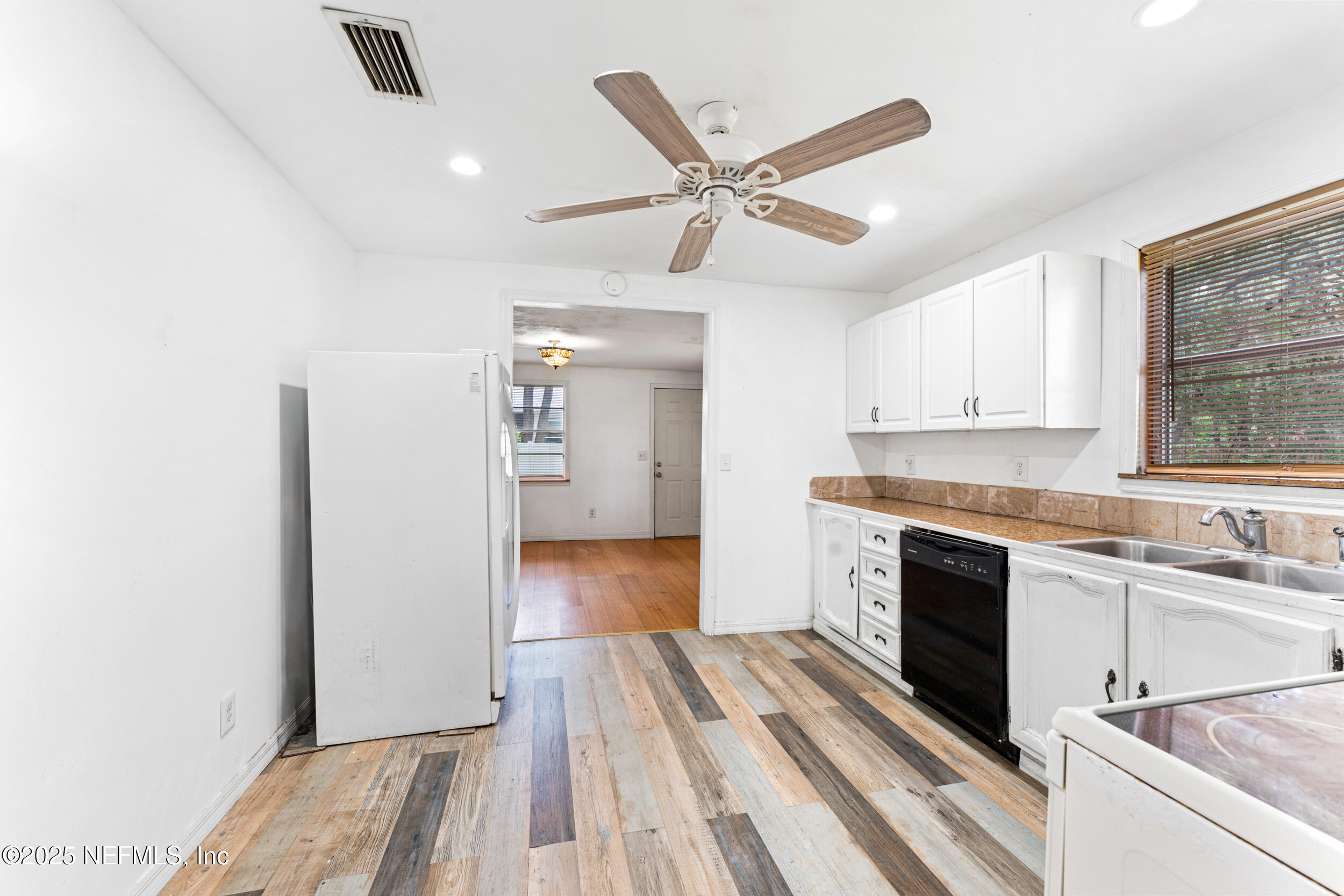 610 Division Street Fernandina Beach, FL 32034 - Photo 17 of 40 a view of a kitchen with a sink dishwasher and wooden floor
