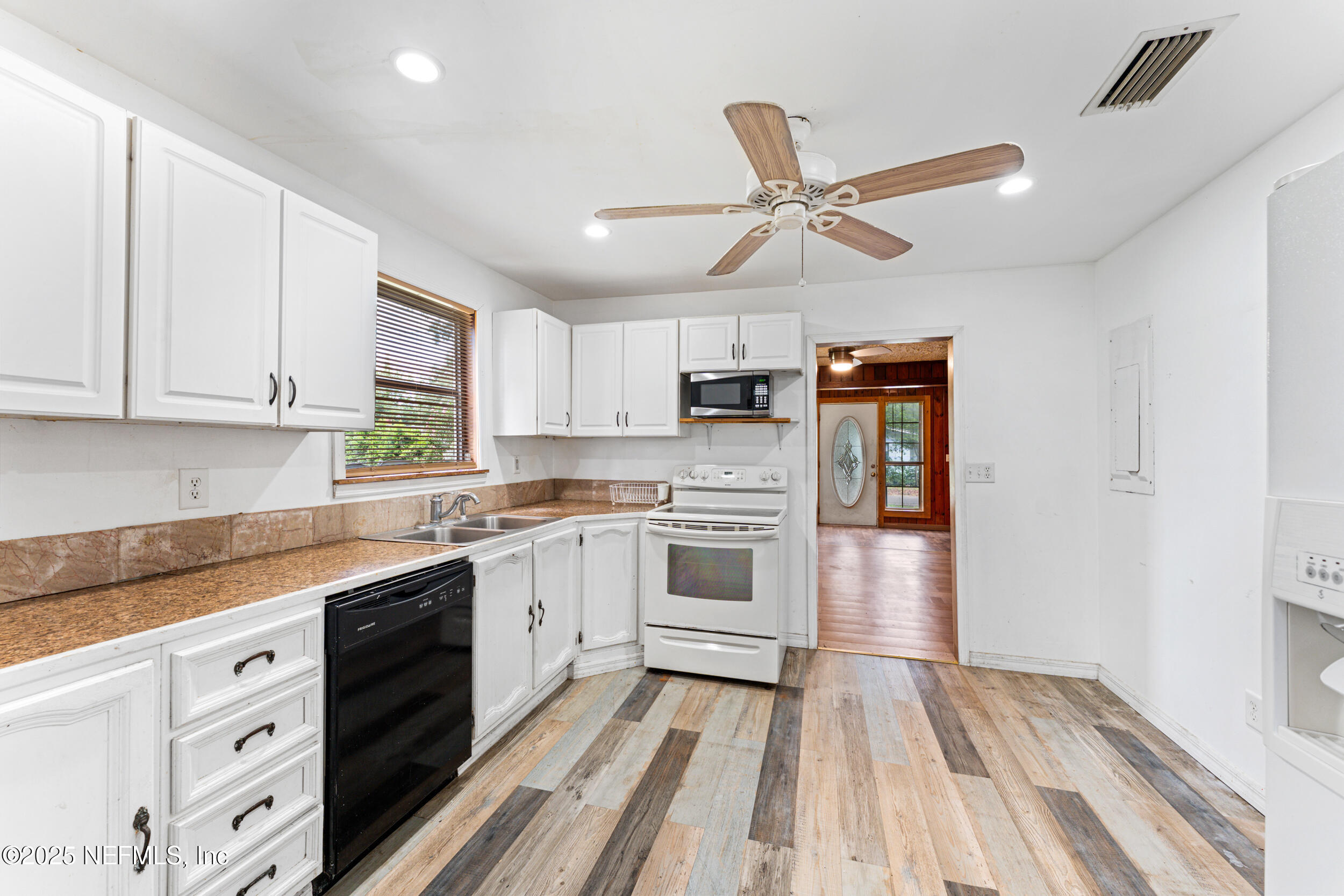 610 Division Street Fernandina Beach, FL 32034 - Photo 19 of 40 a kitchen with granite countertop a white cabinets and white appliances