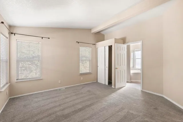 an empty room with windows and closet