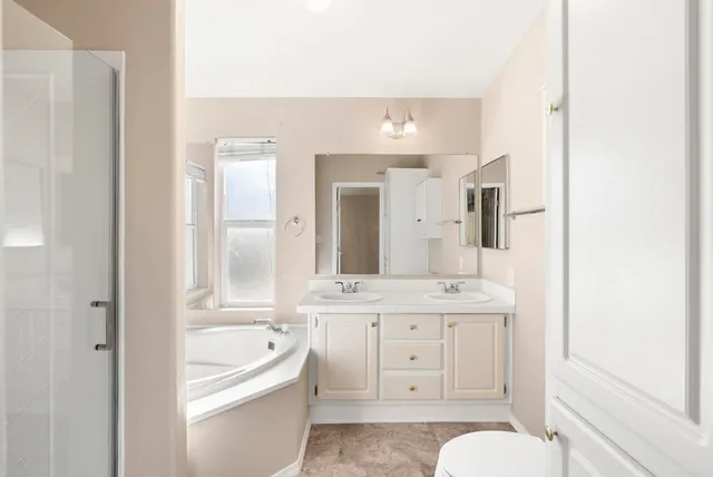 a bathroom with a granite countertop sink toilet a large mirror a bathtub and shower