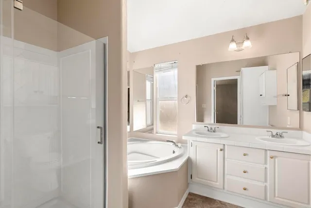 a bathroom with a granite countertop sink mirror and bathtub