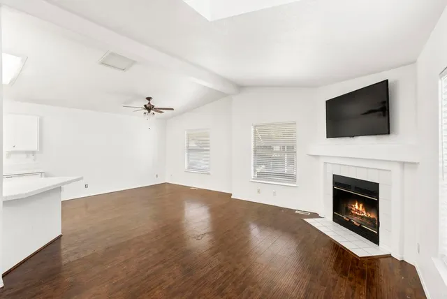 a view of empty room with fireplace and wooden floor