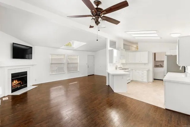 a view of a kitchen with a stove cabinets wooden floor and a fireplace