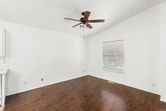 a view of a room with wooden floor and ceiling fan