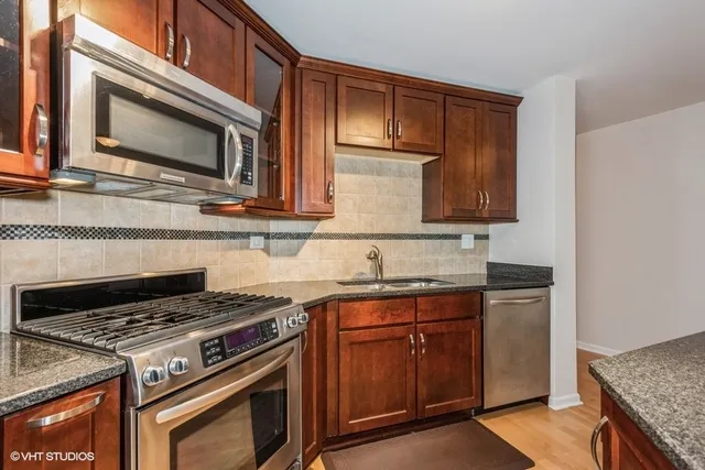 a kitchen with stainless steel appliances granite countertop a stove and a microwave