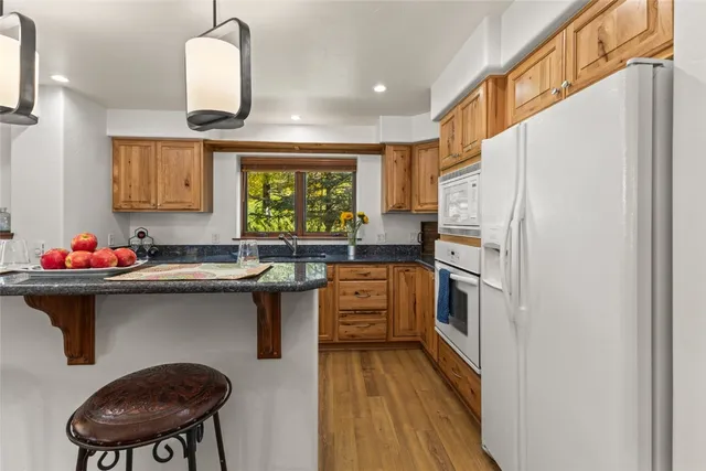 a kitchen with stainless steel appliances a table and chairs in it