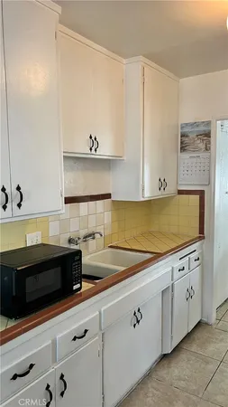 a kitchen with granite countertop white cabinets and white appliances