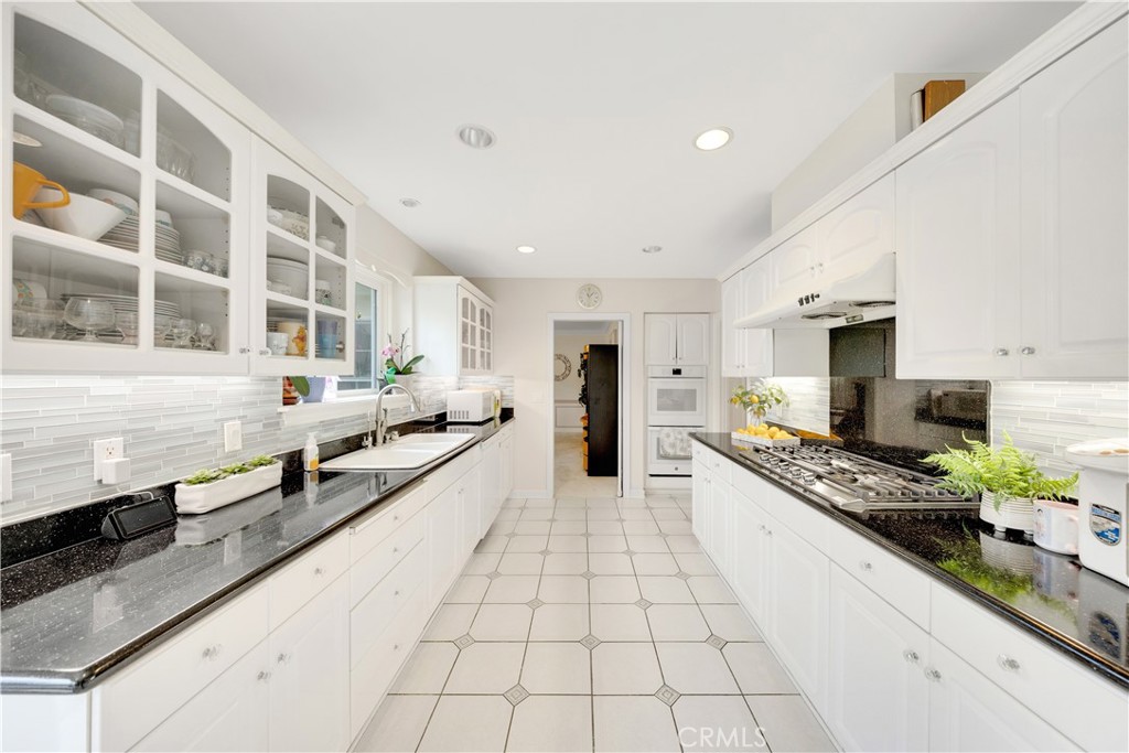 2835 Devonport Road San Marino, CA 91108 - Photo 18 of 54 a large white kitchen with stainless steel appliances kitchen island granite countertop a large counter top a stove and a sink