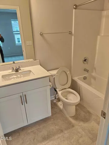 a bathroom with a granite countertop toilet sink and mirror