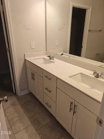 a bathroom with a double vanity sink and mirror