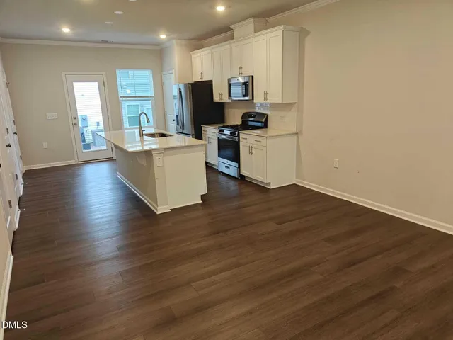 a kitchen with stainless steel appliances a refrigerator and a stove top oven