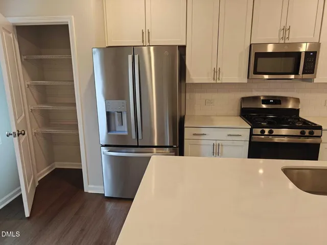 a kitchen with stainless steel appliances a refrigerator stove and microwave