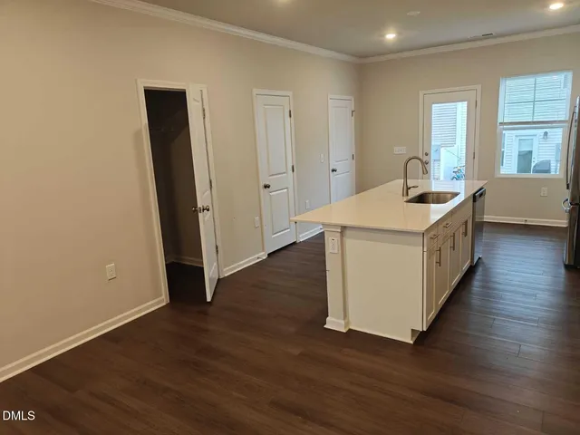 a kitchen with a sink and wooden floor