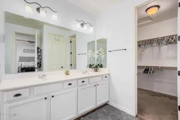 a bathroom with a double vanity sink a mirror a bathtub and shower