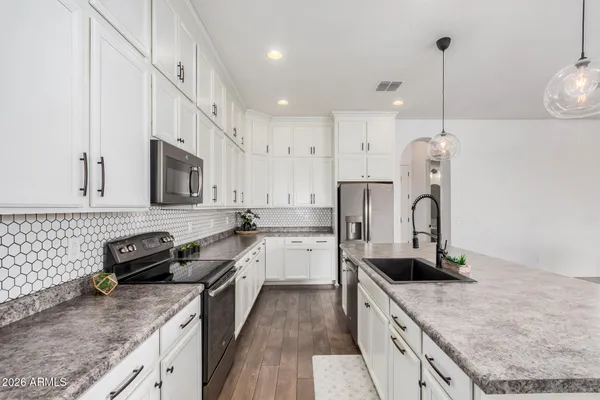 a kitchen with stainless steel appliances granite countertop a sink stove and refrigerator