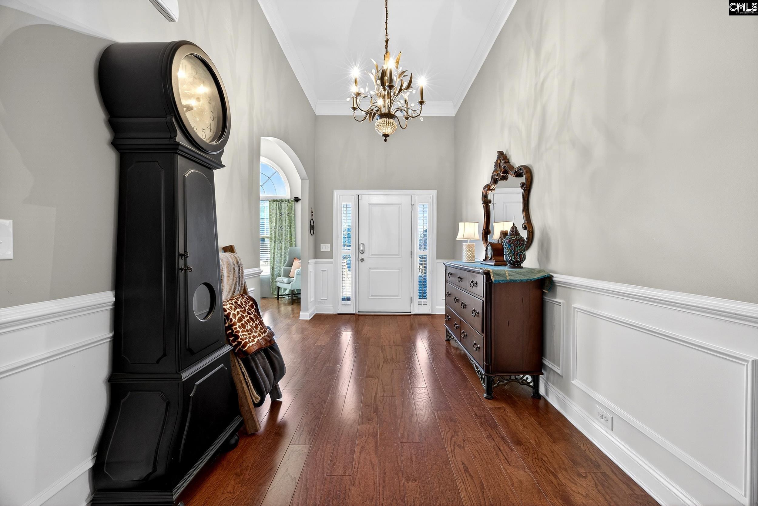 116 Renard Way Gilbert, SC 29054 - Photo 10 of 74 a view of a hallway with wooden floor and a chandelier