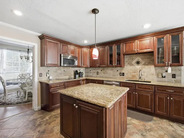 a kitchen with a stove a sink a center island and a window