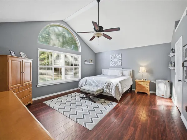 a bedroom with a bed and wooden floor