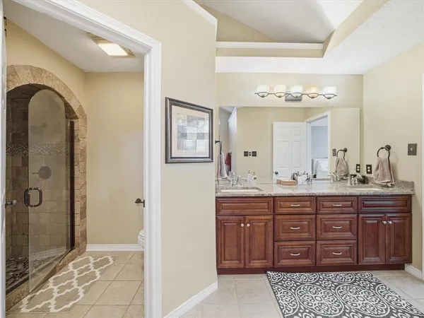a spacious bathroom with a granite countertop sink a mirror and a shower