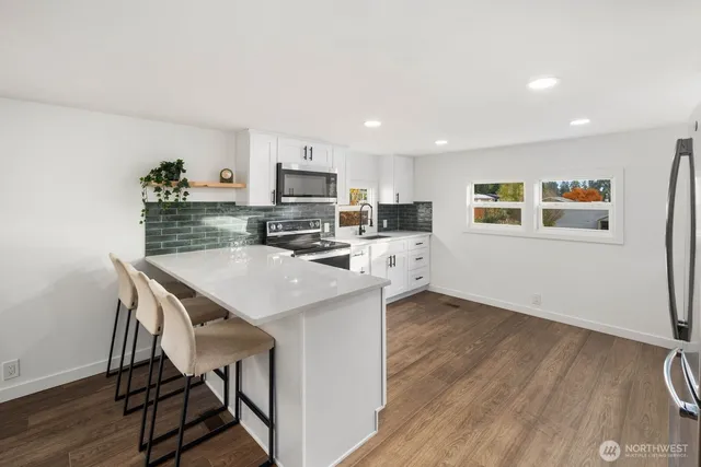 a kitchen with stainless steel appliances a stove microwave and cabinets