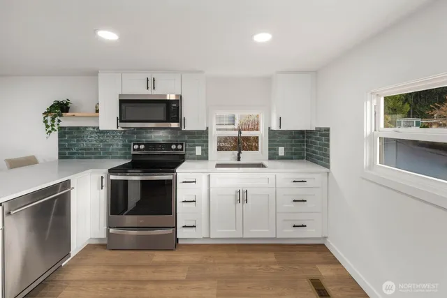 a kitchen with granite countertop a stove top oven and cabinets