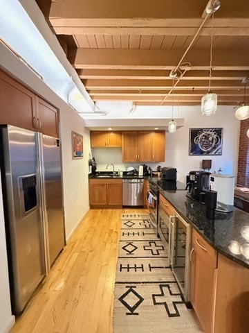 a kitchen with stainless steel appliances kitchen island granite countertop a refrigerator and a stove top oven