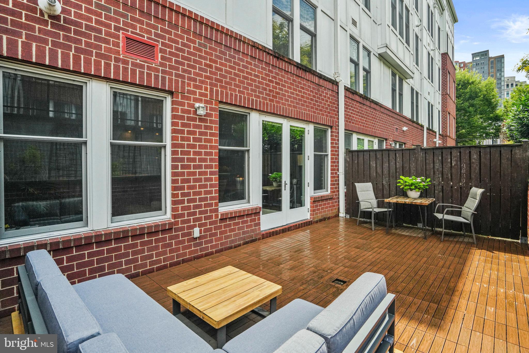 1811 14th Street North, Unit C104 Arlington, VA 22209 - Photo 15 of 44 a view of a patio with table and chairs with wooden floor and fence