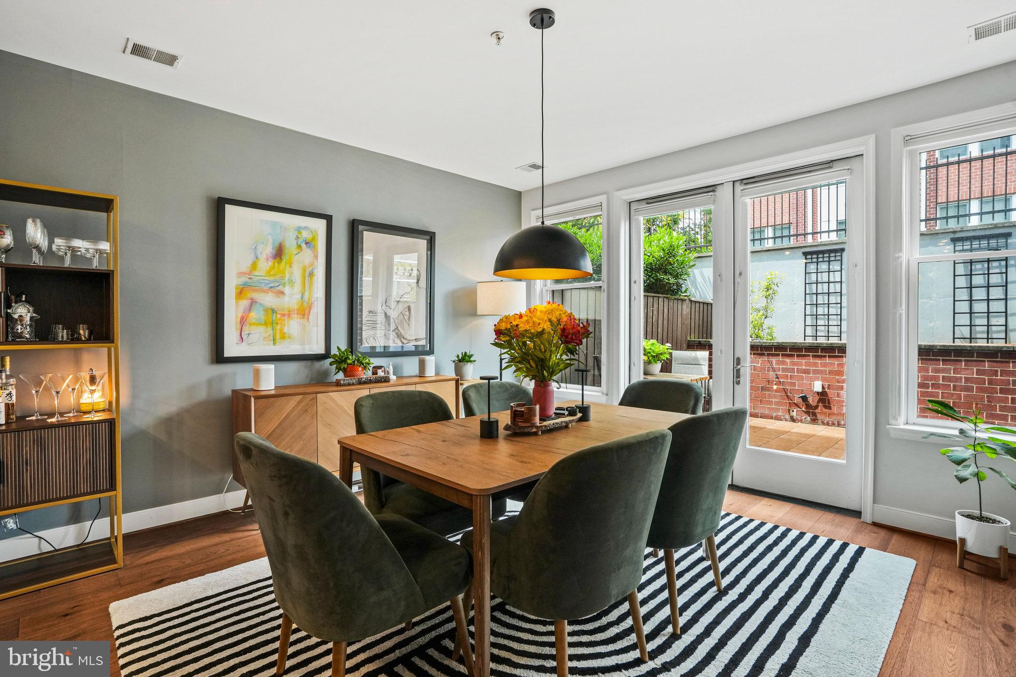 1811 14th Street North, Unit C104 Arlington, VA 22209 - Photo 5 of 44 a dining room with furniture a chandelier and wooden floor