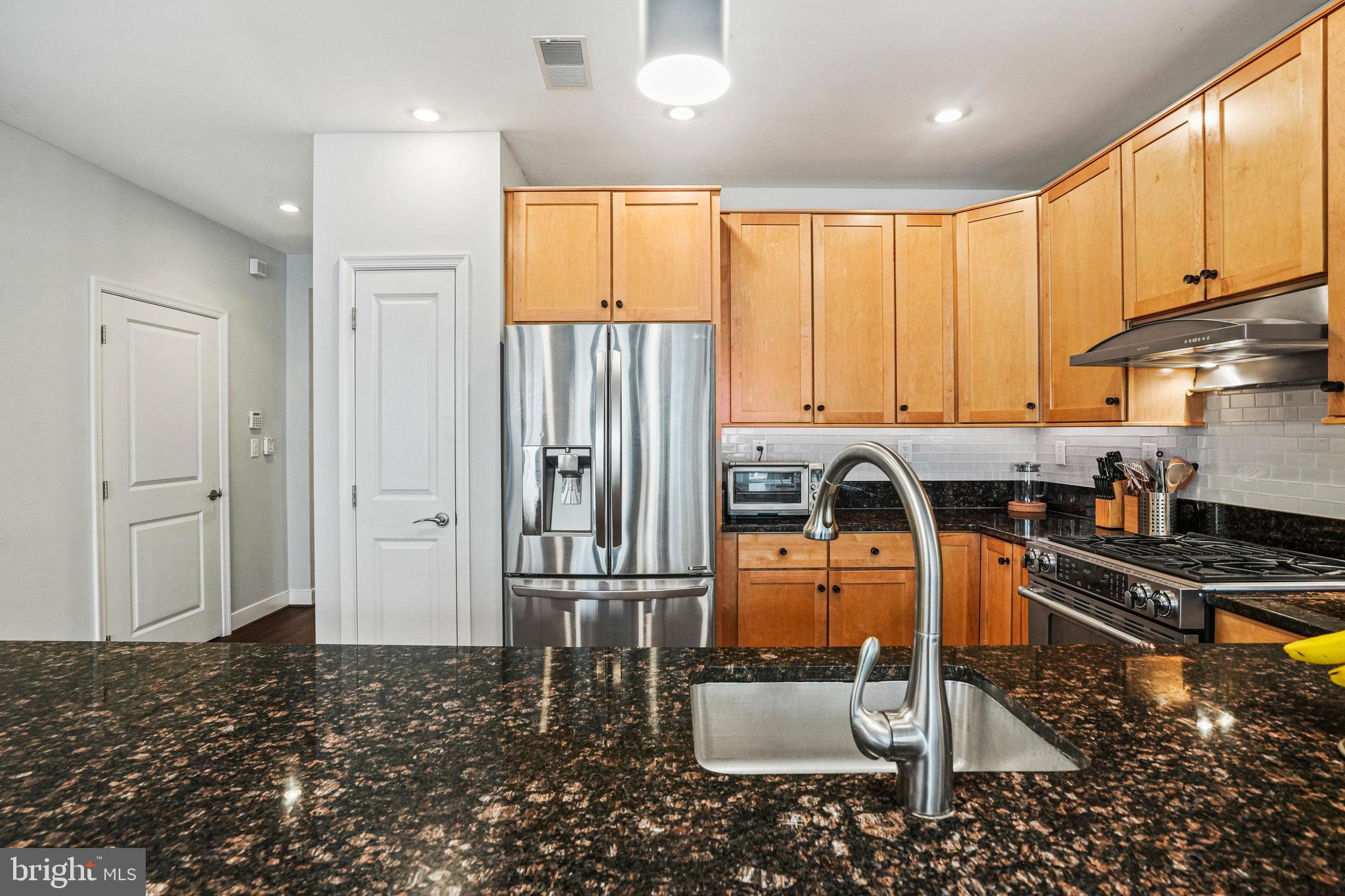 1811 14th Street North, Unit C104 Arlington, VA 22209 - Photo 10 of 44 a kitchen with stainless steel appliances granite countertop a refrigerator and a stove top oven