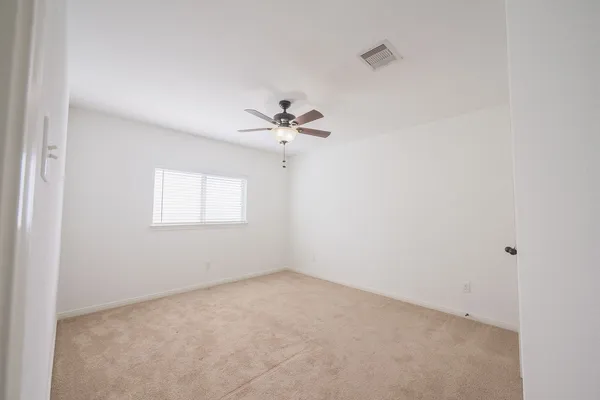 a view of a room with a ceiling fan and a window