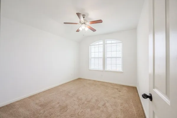 an empty room with windows and fan