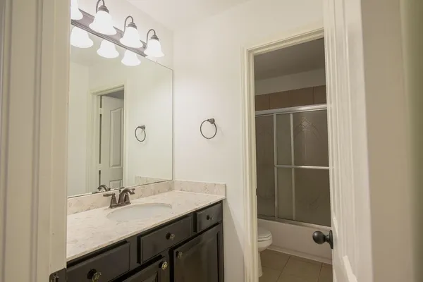 a bathroom with a double vanity sink mirror and shower