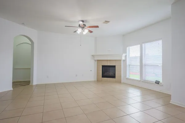 an empty room with windows and fireplace