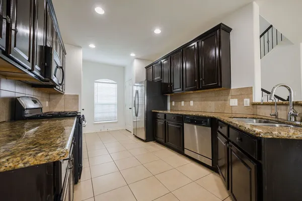 a kitchen with stainless steel appliances granite countertop a sink stove and refrigerator
