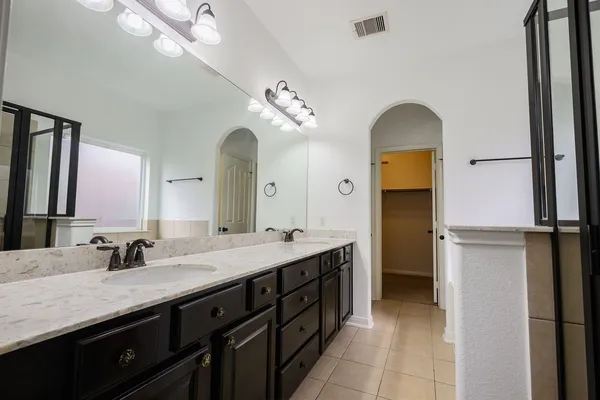 a spacious bathroom with a double vanity sink and a mirror