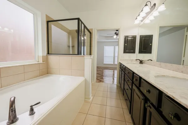a bathroom with a tub sink and mirror