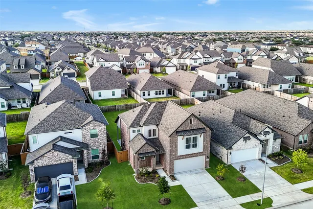 an aerial view of residential houses with outdoor space and parking