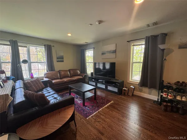 a living room with furniture a flat screen tv and a large window